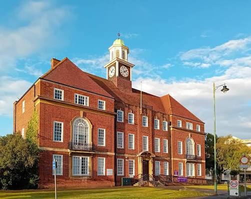 Letchworth Town Hall on Broadway in Letchworth Garden City, Hertfordshire, with its distinctive clock tower against a blue sky.