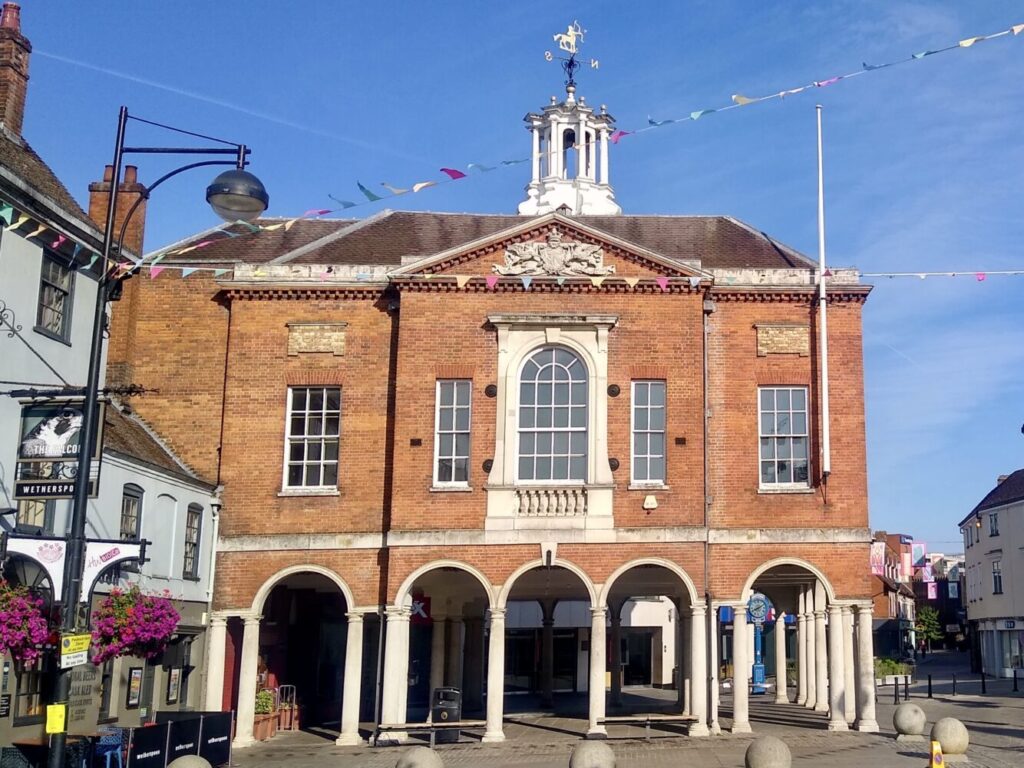 High Wycombe Guildhall in Buckinghamshire, its brick facade decked with colourful bunting on a summer day.