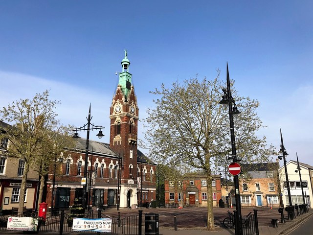 March Town Hall and Market Place in Cambridgeshire, showing the Victorian red-brick clock tower built in 1900 and the surrounding town centre square.